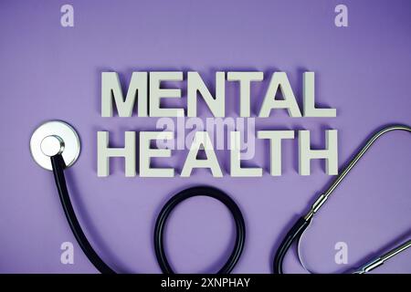 Alphabetbuchstaben und Stethoskop auf violettem Hintergrund, Gesundheitskonzept Stockfoto