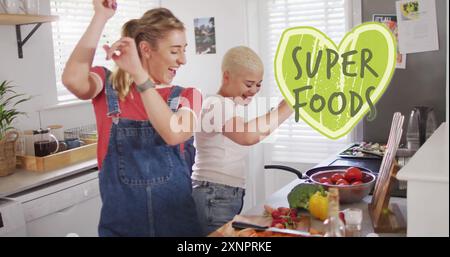 Bild von Super Food Text über diversen weiblichen Paaren, die zu Hause kochen Stockfoto