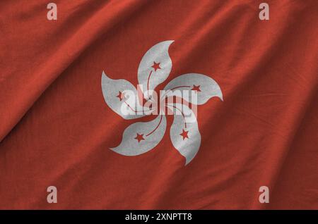 hongkong-Flagge auf gefaltetem welligem Stoff aus altem Tuch in Nahaufnahme dargestellt Stockfoto