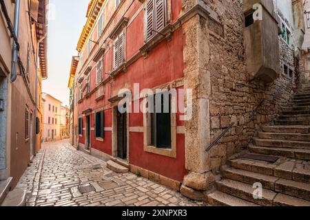 Rovinj, Kroatien - mit Stein gepflasterte Straße und Treppen in der Altstadt von Rovinj. Traditionelle kroatische Häuser in einer Gasse bei Sonnenaufgang an einem Sommermorgen Stockfoto