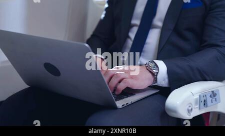 Die Hände des Mannes tippen auf der Laptop-Tastatur. Geschäftsmann, der im Loft-Büro mit Laptop surft. Geschäftsmann, der an einem Laptop arbeitet, aus der Ferne studiert Stockfoto