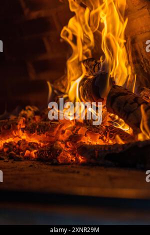 Nahaufnahme von brennendem Brennholz im Backofen mit hellen Flammen und glühender Glut in einem Kamin Stockfoto