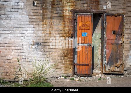 Verlassene Industrielle Ziegelmauer Mit Einem Alten Hölzernen Offenen Garagentor Stockfoto