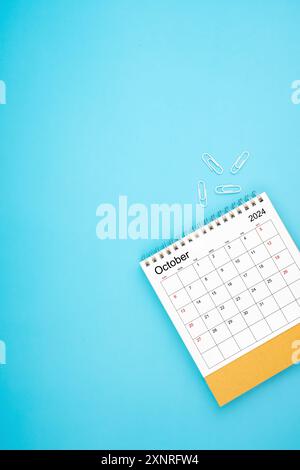 Schreibtischkalender für Oktober 2024 und weiße Büroklammer auf hellblauem Hintergrund Stockfoto