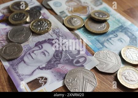 Vereinigtes Königreich - 20. Juli 2024: Eine Nahaufnahme des britischen Geldes. 20- und 5-Pfund-Banknoten, mit Pfund-Münzen und kleineren Stückelungen. GBP Sterling. Stockfoto