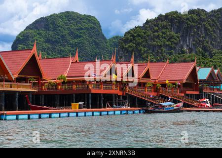 Blick auf das Fischerdorf Nga auf der Insel Koh Panyee, Thailand Phuket, an einem sonnigen Tag. Wunderschöne traditionelle thailändische Häuser mit Berg und blauem Himmel mit Clou Stockfoto