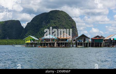 Blick auf das Fischerdorf Nga auf der Insel Koh Panyee, Thailand Phuket, an einem sonnigen Tag. Wunderschöne traditionelle thailändische Häuser mit Berg und blauem Himmel mit Clou Stockfoto