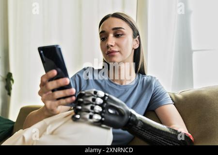 Junge Frau mit Prothese per Handy Stockfoto