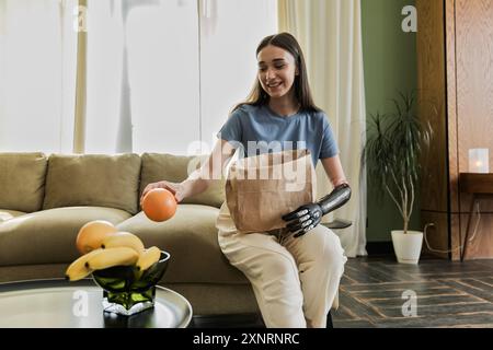 Eine junge Frau mit Prothese legt Früchte aus der Papiertüte Stockfoto