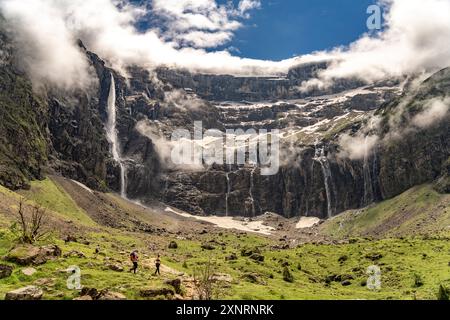 Wanderer im wolkenverhangenen Talkessel Cirque de Gavarnie, UNESCO Welterbe im Nationalpark Pyrenäen bei Gavarnie-Gèdre, Frankreich, Europa | Wanderer A Stockfoto