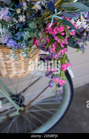 Nahaufnahme eines Fahrradkorbs mit bunten Blumen Stockfoto