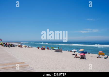 Sonnige Strandszene in Portugal mit klarem blauen Himmel und sanften Wellen Stockfoto