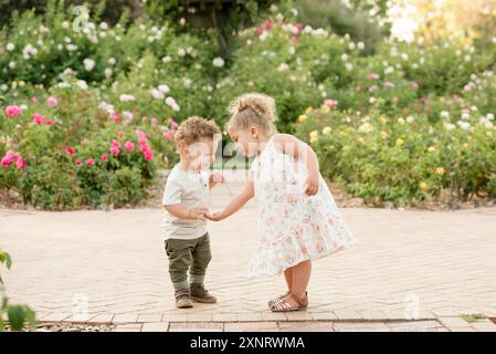 Schwester hilft Bruder im Garten Stockfoto
