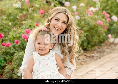 Mutter und Tochter lächelnd in Garten Stockfoto