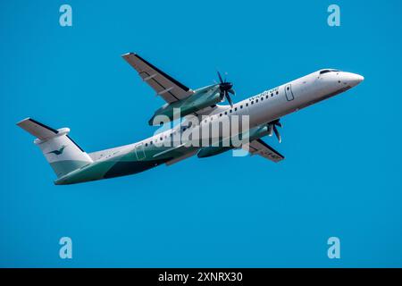 Helsinki/Finnland - 26. JULI 2024: De Havilland Dash 8, betrieben von Wideroe, fliegt gegen einen hellblauen Himmel. Stockfoto