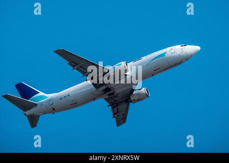 Helsinki/Finnland - 26. JULI 2024: Eine Boeing 737, die von ASL Airlines betrieben wird, fliegt gegen einen hellblauen Himmel. Stockfoto