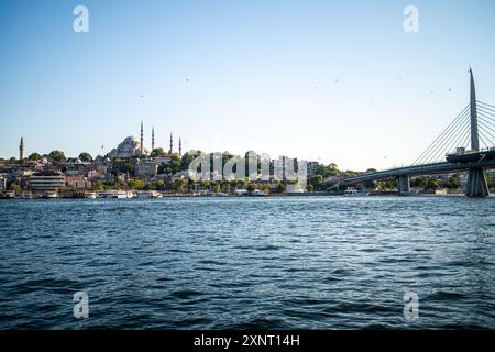 Ein atemberaubender Blick auf die Halic Metro Bridge in Istanbul mit luxuriösen Yachten, die im Vordergrund verankert sind und die Mischung aus modernem Ar der Stadt hervorheben Stockfoto