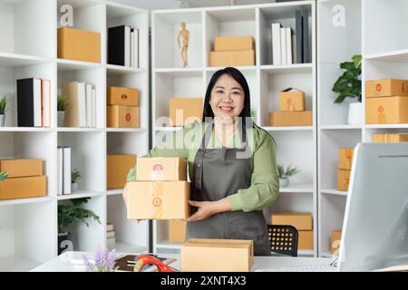 Senior Entrepreneur Starting a Business – selbstbewusste Frau verpackt Kartons in modernen Büroflächen Stockfoto