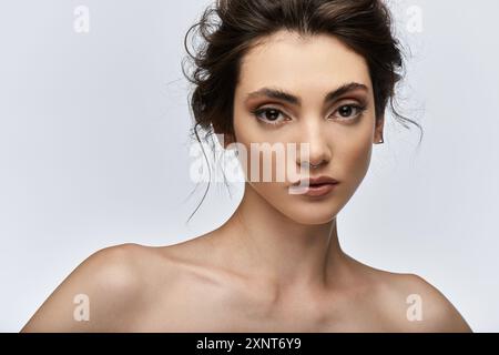 Eine junge Frau mit einem stechenden Blick, Septumpiercing und dezenten Ohrringen starrt den Betrachter an. Stockfoto