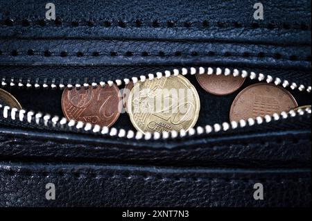 Euro-Tag. Inflation. Entlüftung. Zinssätze. Investitionen. Einsparungen. Das Gehalt einer Frau in der Eurozone. Euro-Geldmünzen in schwarzer Ledertasche mit Stockfoto