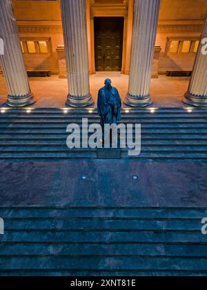 Erhöhter Blick auf die Statue von Benjamin Disraeli, Earl of Beaconsfield, auf den vorderen Stufen der St. Georges Hall, Liverpool UK in der Abenddämmerung. Stockfoto