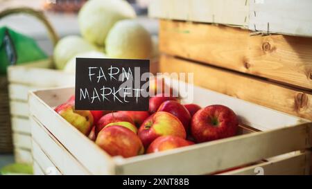Auswahl an leckeren roten Äpfeln mit einem Bauernmarkt Schild an einem Imbissstand mit frischem Bio-Obst und Gemüse. Outdoors Marketplace mit umweltfreundlichen biologischen Produkten aus lokalem Ackerland Stockfoto