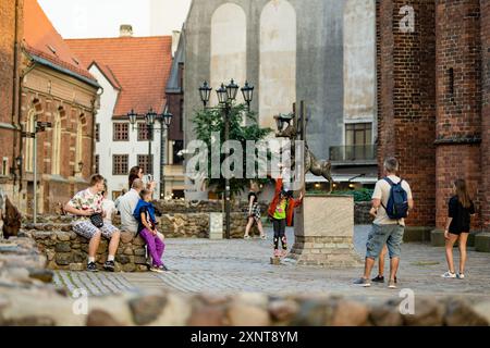 RIGA, LETTLAND - 9. AUGUST 2023: Skulpturen der Bremer Stadtmusiker. Stadtbewohner und Stadtgäste schlendern durch farbenfrohe Kopfsteinpflasterstraßen in Ri Stockfoto