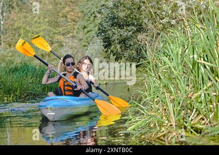 Familien-Kajak, Mutter und Tochter paddeln im Kajak auf dem Fluss Kanu Tour mit Spaß, aktives Wochenende und Urlaub mit Kindern, Fitnesskonzept Stockfoto