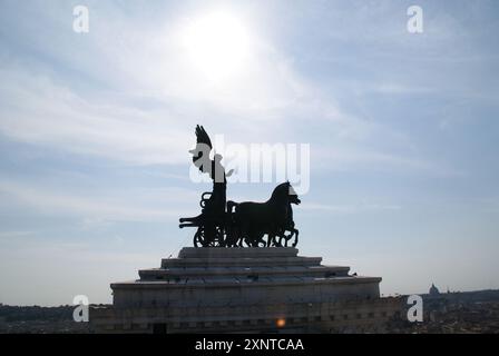 Oben auf Roms „Altare della Patria“, Engel und Pferdekutsche Silhouette über einem dramatischen sonnigen blauen Himmel Stockfoto