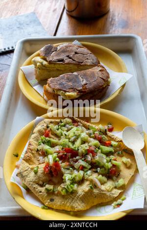 Indische Snacks Masala papad und Brötchen maska werden in einem Café am Straßenrand in Uttarakhand, Indien, serviert. Stockfoto