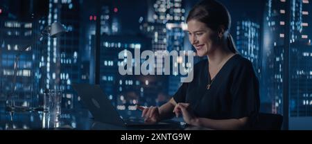 Porträt einer erfolgreichen jungen kaukasischen Geschäftsfrau, die spät in der Nacht an ihrem Schreibtisch sitzt und an einem Laptop arbeitet. Professional Social Media Manager planen E-Commerce-Kampagne. Stockfoto