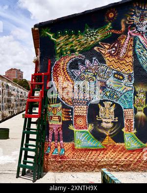 Farbenfrohes Straßengemälde mit einzigartiger Graffiti-Kunst an einer Gebäudewand mit Leiter. Die Szene fängt Kreativität, Straßenkunst-Kultur und urbanes Experience ein Stockfoto