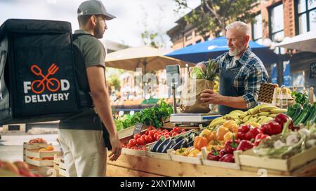 Food Delivery Courier holt eine Online-Marketplace-Bestellung mit Bio-Obst und -Gemüse von einem Bauernmarkt ab. Fröhlicher Straßenhändler, der eine recycelte Papiertüte mit frischen Produkten überreicht Stockfoto