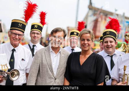 Herne, Deutschland. August 2024. Hernes Oberbürgermeister Frank Dudda (SPD, Mitte links) und Mona Neubaur (Bündnis 90/die Grünen), NRW-Ministerin für Wirtschaft, Industrie, Klimaschutz und Energie, stehen mit dem Bergarbeiterchor bei der offiziellen Eröffnung der 540. Cranger Kirmes. Mit rund 500 Schaustellern und zuletzt rund 3,8 Millionen Besuchern ist die Cranger Kirmes eine der größten Messen in Deutschland. Quelle: Christoph Reichwein/dpa/Alamy Live News Stockfoto