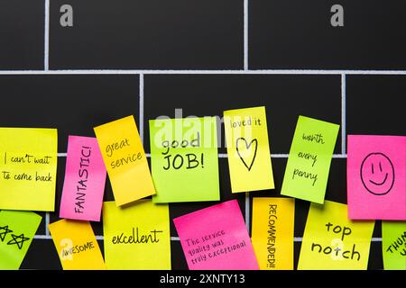 Farbenfrohe Haftnotizen mit positiven und ermutigenden Botschaften auf einer Pinnwand. Kundenerfahrung, Feedback und Zufriedenheitskonzept. Stockfoto