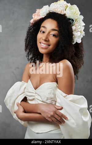 Eine wunderschöne afroamerikanische Braut trägt ein weißes Hochzeitskleid und eine Blumenkrone. Stockfoto