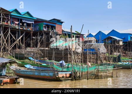 Malerischer Blick auf lebendige Pfahlhäuser und schwimmende Boote im schwimmenden Dorf Tonle SAP in Kambodscha, das traditionelle Leben am Wasser zeigt. Stockfoto