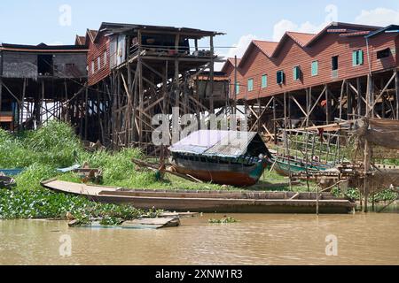 Bild von traditionellen Pfahlhäusern und Holzbooten am Tonle SAP Lake, Kambodscha. Zeigt den einzigartigen Lebensstil und die Architektur des schwimmenden Dorfes. Stockfoto