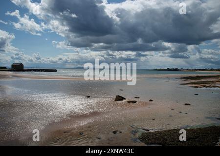 Die Flut kommt aus, wenn sich stürmische Wolken über dem Hafen von elie Fife Scotland sammeln Stockfoto