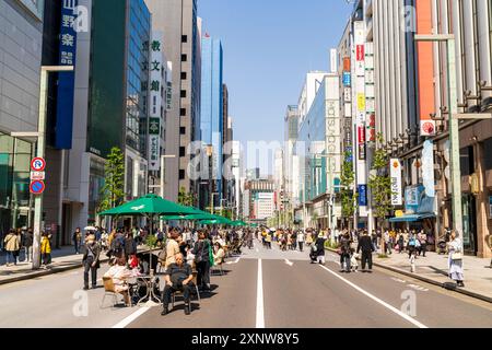 Menschen, die am Wochenende in Hokosha Tengoku, wenn die Straße für den Verkehr gesperrt ist, in der berühmten Einkaufsstraße Ginza in der Frühlingssonne spazieren gehen. Stockfoto