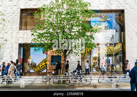 Im Louis Vuitton Flagship Store spazieren Sie an Schaufenstern vorbei, während die Sonne im Frühling scheint. Mehrere Fahrräder auf dem Bürgersteig. Stockfoto