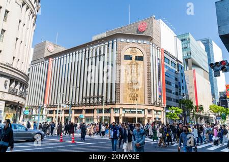 Blick auf die Straße von Hunderten von Menschen, die an einem sonnigen Tag die Kreuzung überqueren, an der Kreuzung vor dem Wahrzeichen Mitsukoshi Ginza Gebäude. Stockfoto