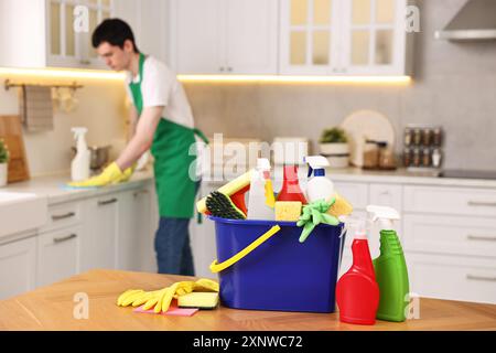 Professioneller Hausmeister, der in der Küche arbeitet, konzentriert sich auf Eimer mit Zubehör. Reinigungsservice Stockfoto