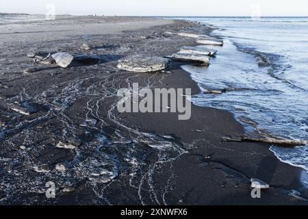 Schmelzende Eisschollen mit Sand lagen an einem Wintertag an der Küste der Ostsee, Landschaftsfoto des Finnischen Golfs Stockfoto