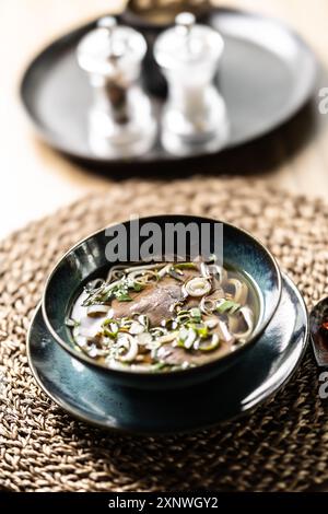Pho Bo vietnamesische frische Reisnudelsuppe mit Rindfleisch, Zwiebeln, Limette, Kräutern und Chili-Dekoration. Stockfoto