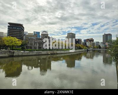 Das Hiroshima Peace Memorial, ursprünglich die Hiroshima Prefectural Industrial Promotion Hall und heute allgemein Genbaku Dome, Atombombendom oder A-Bomb Dome genannt, ist Teil des Peace Memorial Park in Hiroshima und wurde 1996 zum UNESCO-Weltkulturerbe erklärt. Das Gebäude war das einzige Gebäude, das im Bereich der Atombombenangriffe auf Hiroshima am Ende des Zweiten Weltkriegs stand. Die Ruine des Saals dient als Gedenkstätte für die über 140.000 Menschen, die bei dem Bombenanschlag ums Leben kamen. Sie wird dauerhaft in einem Zustand der erhaltenen Ruine gehalten, um an die zerstörerische e e zu erinnern Stockfoto