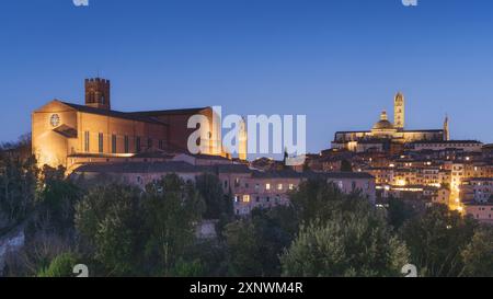 Blaue Stunde über der Skyline von Siena. Von links die Basilika San Domenico, auch bekannt als Basilika Cateriniana, der Turm von Mangia und die Kathedrale Stockfoto