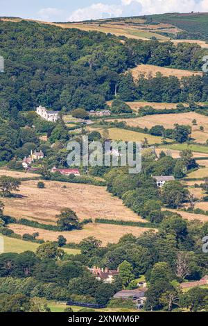 Eine lange Aufnahme des Dorfes Selworthy unterhalb des Minehead North Hill im Exmoor National Park, Somerset, England, Großbritannien Stockfoto