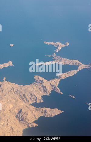 Die Meerenge von Hormuz aus der Vogelperspektive zeigt das zerklüftete Gelände und das ruhige blaue Wasser. Diese strategische Wasserstraße verbindet den Persischen Golf und den Golf von Oman und unterstreicht seine geografische Bedeutung. Stockfoto