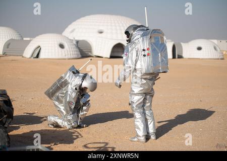 Zwei Astronauten in Raumanzügen führen Feldversuche in der Wüste des südlichen Oman durch, die dem Marsgelände sehr ähnlich ist, als Teil einer simulierten Mars-Mission, die vom Austrian Space Forum organisiert wird. Stockfoto